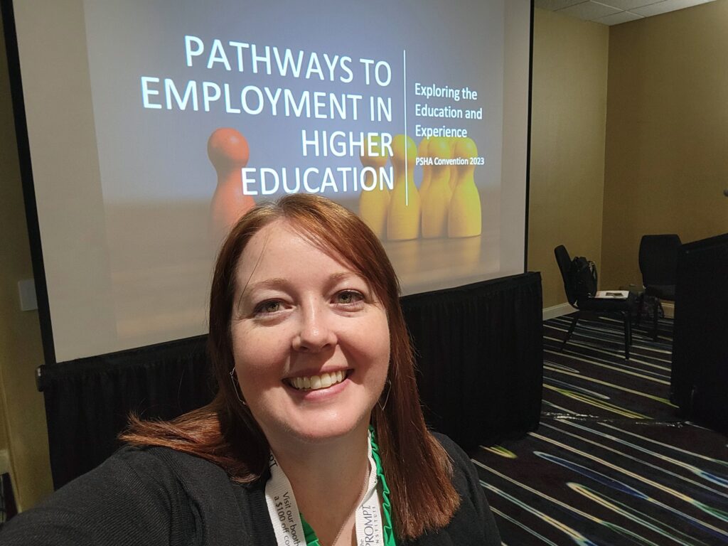 Laura in front of a neurodiversity program presentation called Pathways to Employment in Higher Education